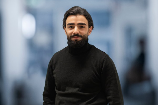 Portrait photo of Fatih Özgan in front of a grey/blue background