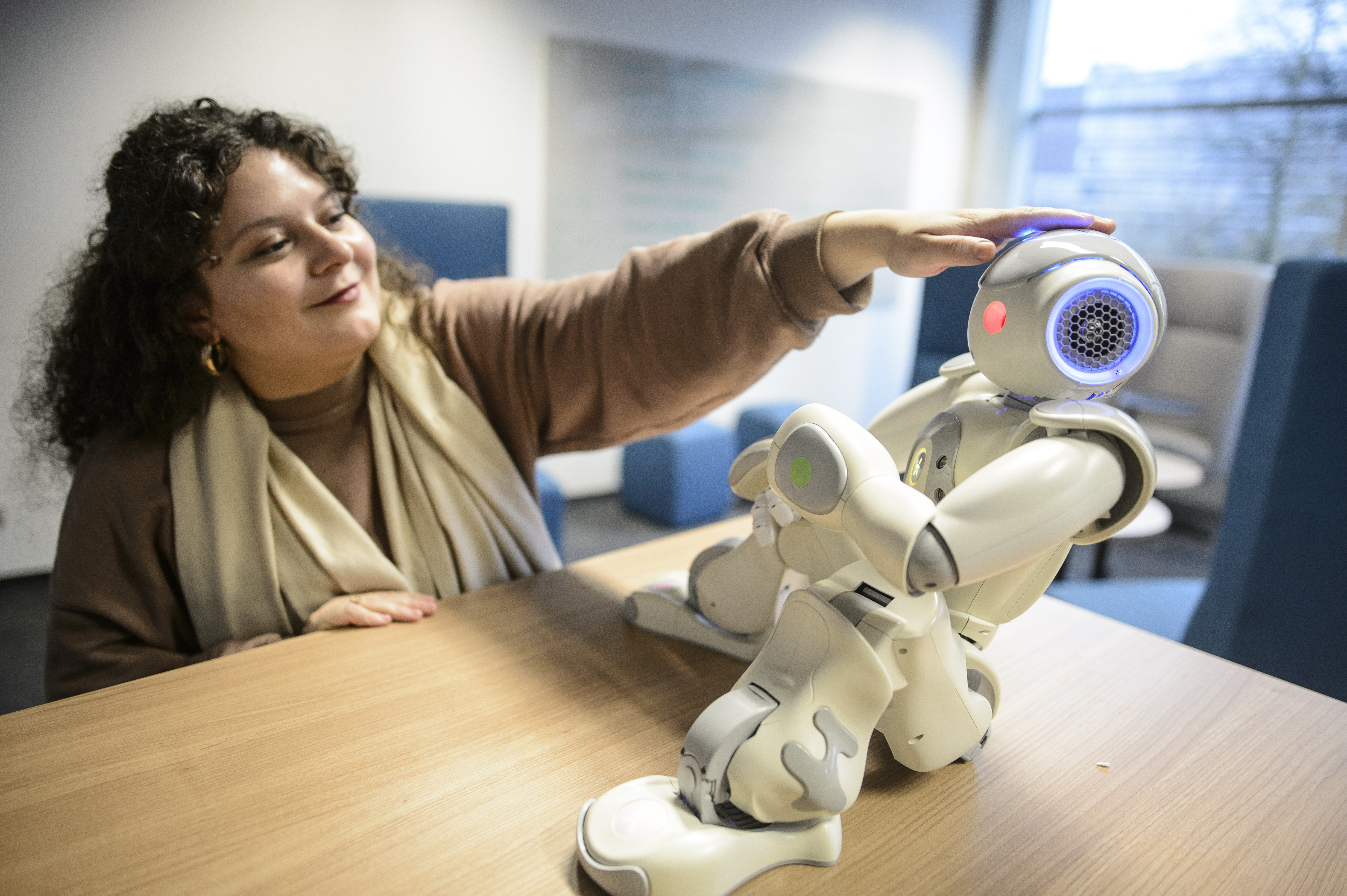 Studentin interagiert mit Roboter