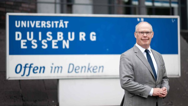 Ulf Richter vor dem Logo der Universität Duisburg-Essen (UDE)